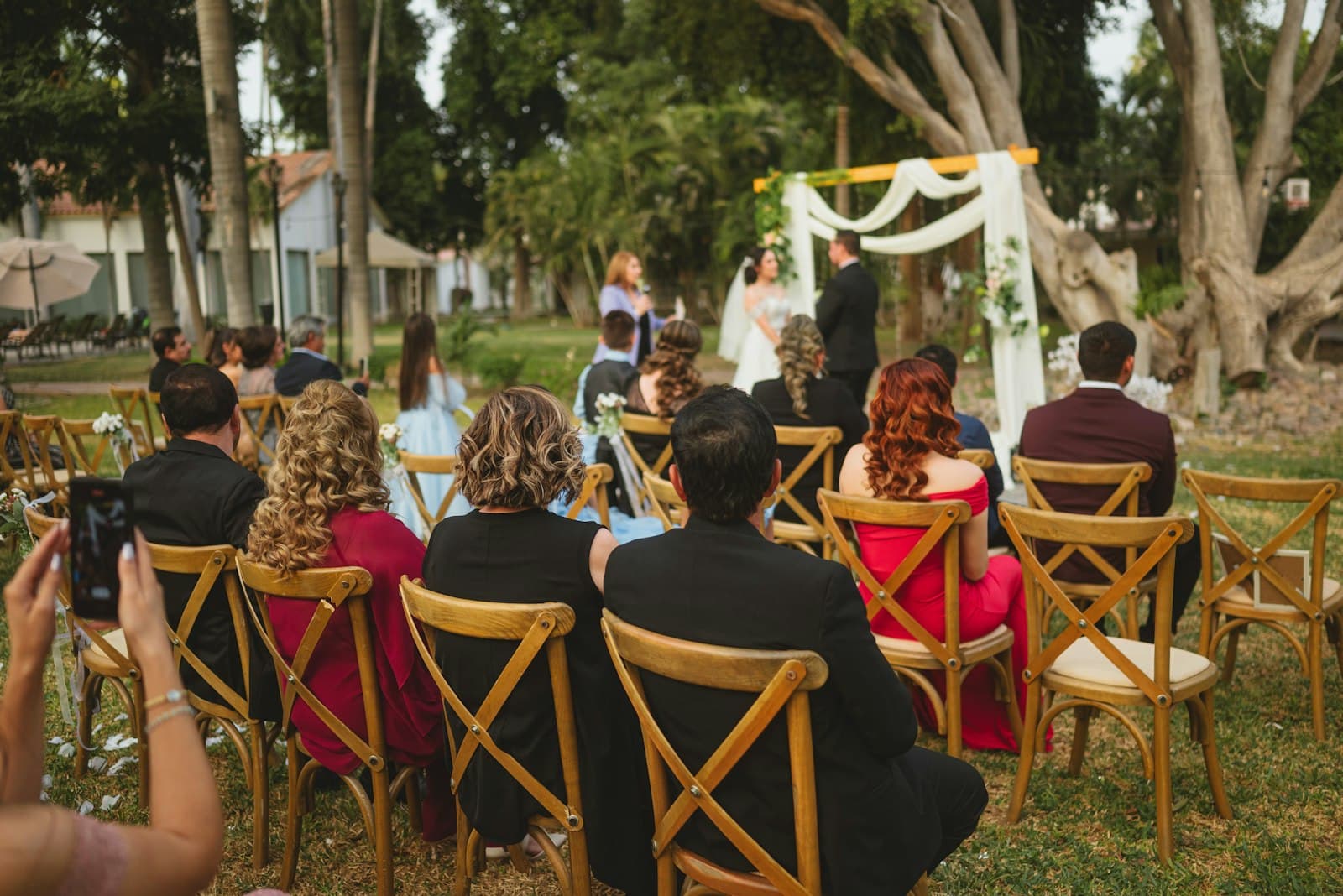 Convidados sentados em uma cerimônia de casamento ao ar livre