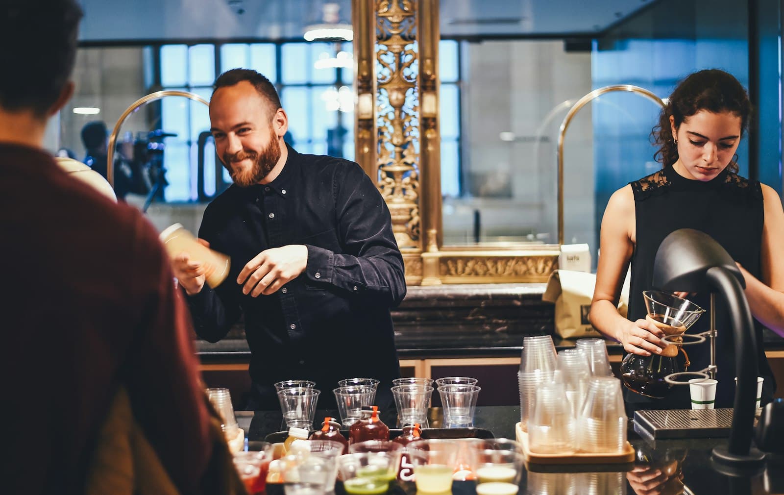 Bartenders preparando drinks no balcão de um bar